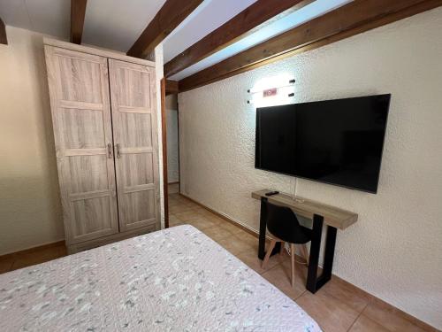 a bedroom with a bed and a television on the wall at LA CASONA DE PALMIRA in Caín
