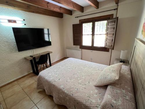 a bedroom with a bed and a flat screen tv at LA CASONA DE PALMIRA in Caín