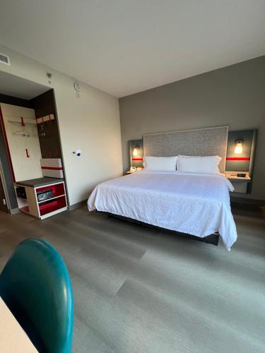 a bedroom with a large bed and a blue chair at avid hotels - Guadalajara Av Vallarta Pte by IHG in Guadalajara