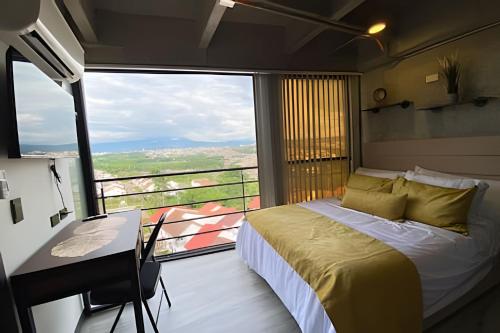 a bedroom with a bed and a large window at Epic Suites x Ahead in Pereira