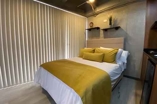 a bedroom with a large bed with yellow pillows at Epic Suites x Ahead in Pereira