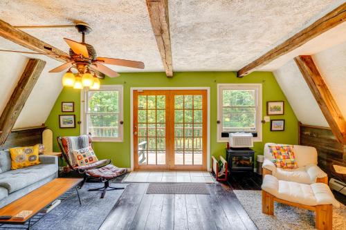 a living room with green walls and a ceiling fan at A-Frame Cabin with Furnished Deck in Becket! in Becket