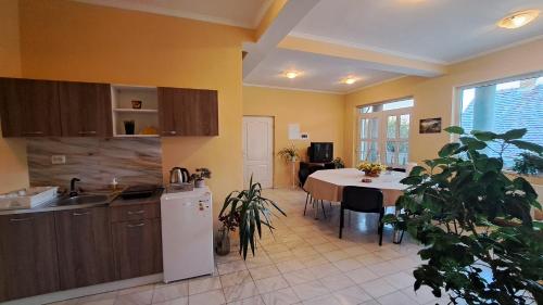 a kitchen with a table and a white refrigerator at Erika Panzió in Ditrău