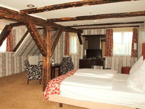 a bedroom with a large bed with wooden beams at Märchenhotel in Bergen auf Rügen