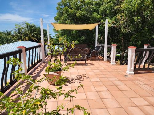 a patio with a table and chairs on a deck at Caribbean Shores Belize in Hopkins