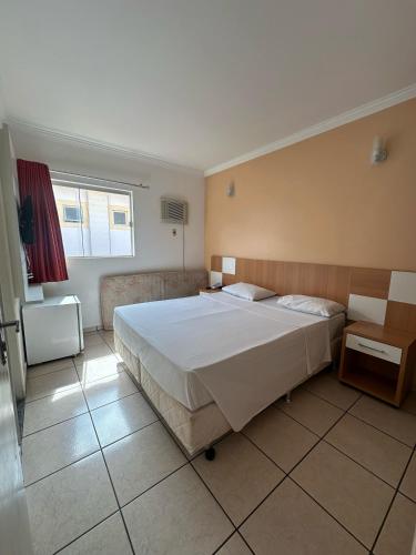 a bedroom with a large white bed in a room at Nobreza Fiori Turismo em Caldas Novas Diroma Fiori SEM ROUPAS DE CAMA BANHO E REFEIÇÕES A SEREM CONTRATADAS SEPARADAMENTE DA RESERVA in Caldas Novas