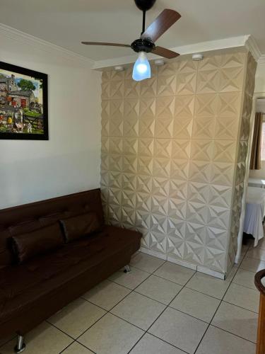 a living room with a couch and a ceiling fan at Nobreza Fiori Turismo em Caldas Novas Diroma Fiori SEM ROUPAS DE CAMA BANHO E REFEIÇÕES A SEREM CONTRATADAS SEPARADAMENTE DA RESERVA in Caldas Novas
