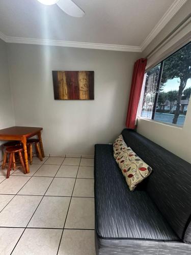 a living room with a couch and a table at Nobreza Fiori Turismo em Caldas Novas Diroma Fiori SEM ROUPAS DE CAMA BANHO E REFEIÇÕES A SEREM CONTRATADAS SEPARADAMENTE DA RESERVA in Caldas Novas