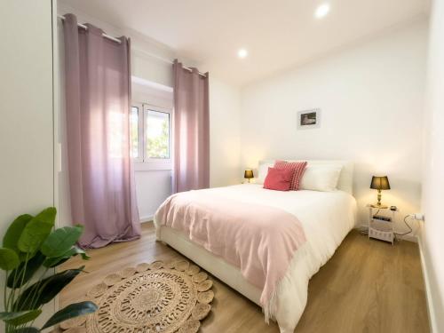 a bedroom with a large white bed with pink curtains at River 2-Bedroom Apartment with Terrace in Alcântara in Lisbon