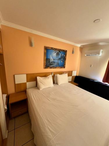 a bedroom with a large bed with white sheets at Nobreza Fiori Turismo em Caldas Novas Diroma Fiori SEM ROUPAS DE CAMA BANHO E REFEIÇÕES A SEREM CONTRATADAS SEPARADAMENTE DA RESERVA in Caldas Novas