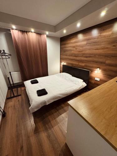 a bedroom with a bed and a wooden wall at EksPorta Apartments 6 in Rīga