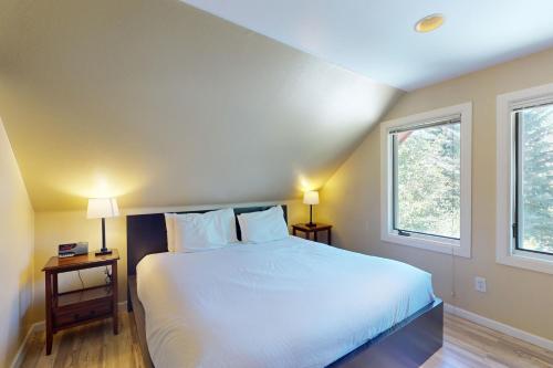 a bedroom with a white bed and two windows at Valley View in Vail