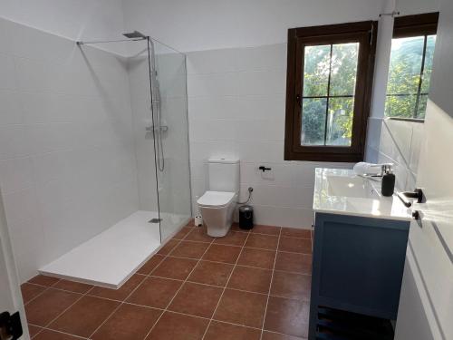a bathroom with a shower and a toilet and a sink at Casa Rural Can Ricós - El Mirador del Montseny in Vallgorguina