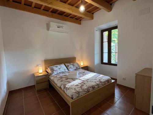 a bedroom with a bed and two night stands with lights at Casa Rural Can Ricós - El Mirador del Montseny in Vallgorguina
