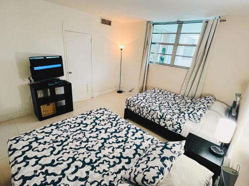 a bedroom with two beds and a television in it at Miami Hollywood Bay View on the Beach in Hollywood