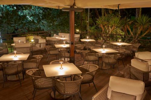 an outdoor restaurant with tables and chairs and candles at Terra Nostra Garden Hotel in Furnas
