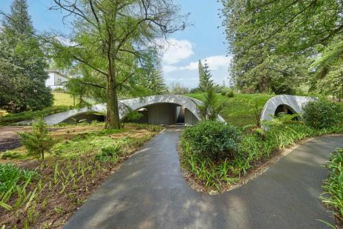 a walkway with a stone bridge in a park at Terra Nostra Garden Hotel in Furnas