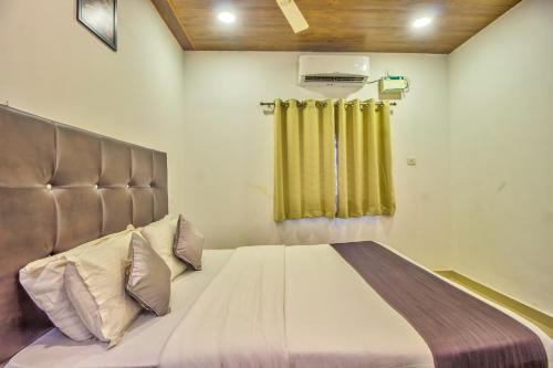 a large bed in a room with a window at Beach Comforts By Balaji Inn in Calangute