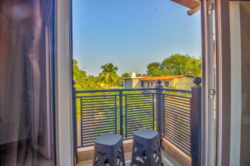 a balcony with a view of a palm tree at Beach Comforts By Balaji Inn in Calangute