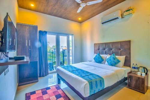 a bedroom with a bed and a balcony at Beach Comforts By Balaji Inn in Calangute