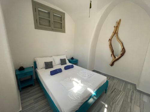 ein Schlafzimmer mit einem Bett und einem Spiegel an der Wand in der Unterkunft Era Tefra in Éxo Goniá