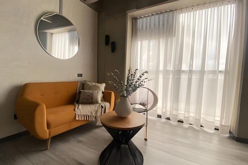 a living room with a couch and a table and a mirror at Epic Suites x Ahead in Pereira