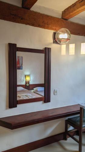 a mirror on the wall of a bedroom at Pousada dos Veleiros in Nova Almeida
