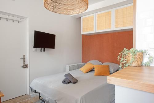 - une chambre avec un lit et une télévision murale dans l'établissement Le Méditerranéen studio proximité Garonne et Capitole, à Toulouse
