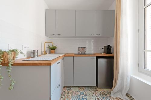 une cuisine avec des armoires blanches et un comptoir dans l'établissement Le Méditerranéen studio proximité Garonne et Capitole, à Toulouse