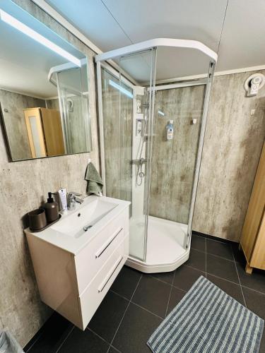 ein Badezimmer mit einem weißen Waschbecken und einer Dusche in der Unterkunft ComfyCorner 4 bedroom apartment in Sola