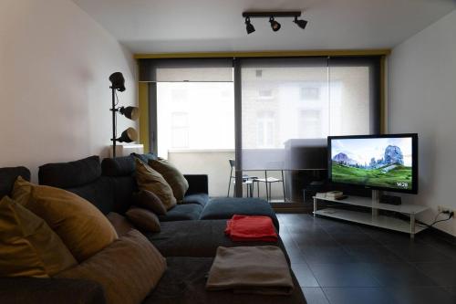 a living room with a couch and a flat screen tv at City Escape - Gratis Parkeren - Centrum Aalst in Aalst