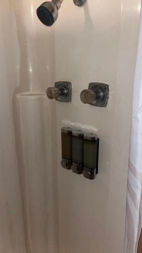 een witte douche met drie knoppen aan de muur bij Hideaway at Columbia in Shreveport