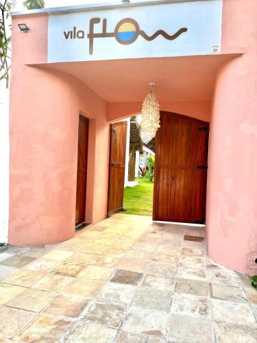 a pink building with a door and a sign on it at Pousada Vila Flow in Cumbuco
