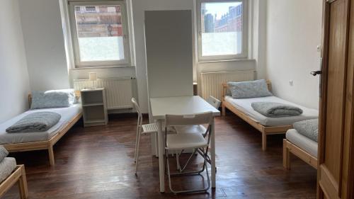 a room with three beds and a table and chairs at Monteurszimmer in Hof in Hof