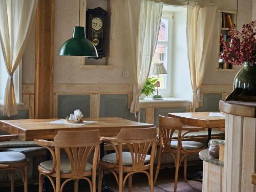 a dining room with tables and chairs and a clock at Stará škola in Dolní Malá Úpa