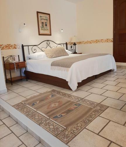 a bedroom with a bed with a rug on the floor at Casa los Cantaros Hotel Boutique in Oaxaca City