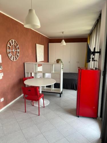 a room with a table and a red chair and a red refrigerator at Gerenzano Apartments in Gerenzano