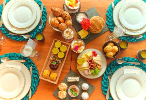 a table topped with plates and bowls of food at Almareia Boutique Hotel in Praia dos Carneiros
