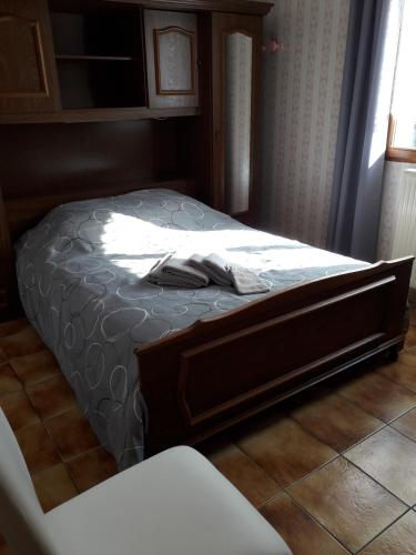 - une chambre avec un lit doté d'un cadre en bois dans l'établissement appartement 3 personnes, à Plombières-les-Bains