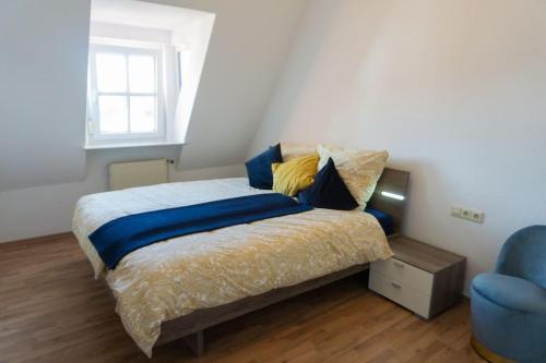 a bedroom with a bed and a blue chair at Casa Burgplatz - Maisonettewohnung in Hüfingen