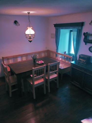 a dining room with a table and chairs and a chandelier at Chalupa Vagner, Pernek in Horní Planá