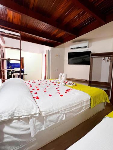 a bedroom with a bed with red roses on it at Pousada Caravelas de Pinzón in Cabo de Santo Agostinho