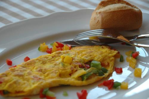 a white plate with an omelet and a fork and bread at Agriturismo Sambuco in Pastrengo