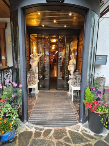 a building entrance with two mannequins in the doorway at dala Hotel & Apartments in Leukerbad