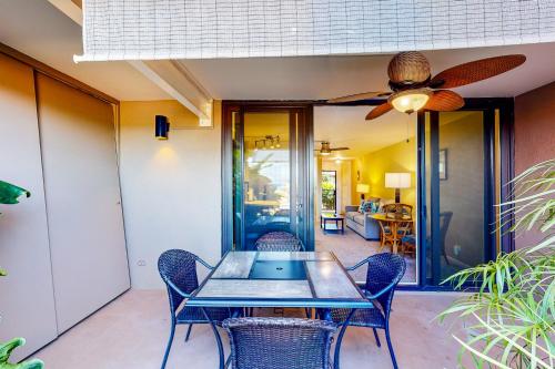 a dining room with a table and chairs and a ceiling fan at Hale Ono Loa Condo in Kahana