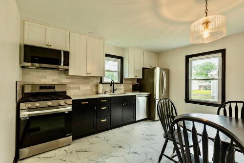 a kitchen with black cabinets and a table with chairs at Speedway Finish Line House in Indianapolis