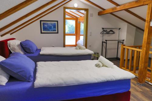 a room with three beds with blue and white sheets at Holiday Homes Mujo Bejzin in Račić