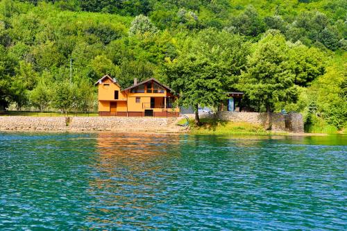 a house on the shore of a body of water at Holiday Homes Mujo Bejzin in Račić