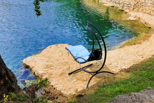 a blue chair sitting next to a body of water at Holiday Homes Mujo Bejzin in Račić