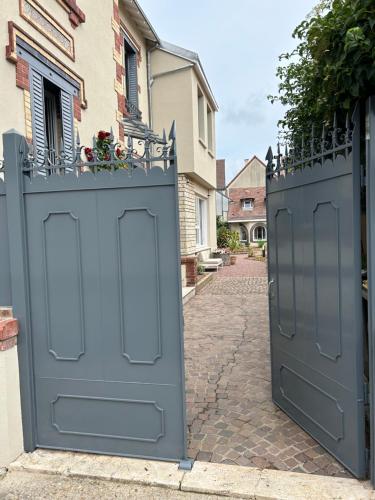 a pair of blue gates on a street at Le Carré Courtois in Luisant